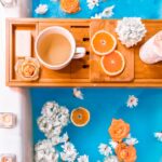 filled mug on brown wooden bathtub tray