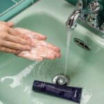 person washing hands on sink